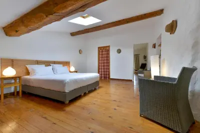 a bedroom with a bed and a table and chairs at Domaine De Fraisse in Leuc