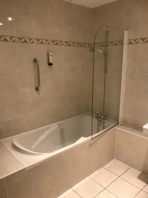 a bathroom with a bath tub with a shower at Logis Hôtel restaurant Les Minotiers in Mirepoix