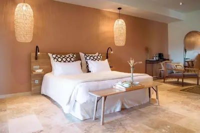 a bedroom with a large white bed and a table at Château L'Hospitalet Wine Resort Beach & Spa in Narbonne