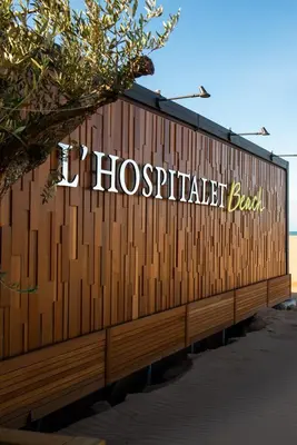 a wooden fence with the words hospitaliestacked back on it at Château L'Hospitalet Wine Resort Beach & Spa in Narbonne