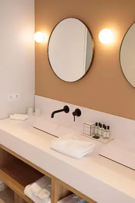 a bathroom with a sink and a mirror at Château L'Hospitalet Wine Resort Beach & Spa in Narbonne