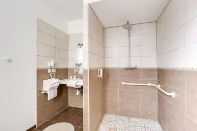 a bathroom with a shower and a sink at Hôtel Du Midi in Narbonne