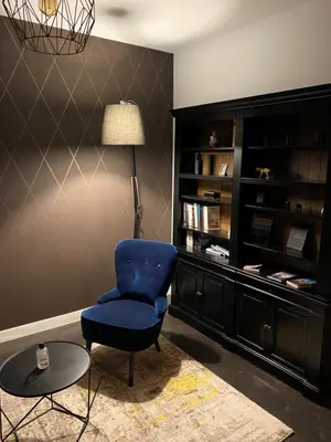 a living room with a blue chair and a table at La Forge in Montséret