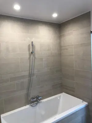 a bathroom with a bath tub with a shower at La Forge in Montséret