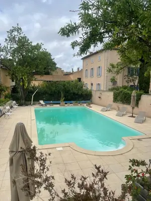a swimming pool in a courtyard with a building at Montagne d'Alaric in Moux