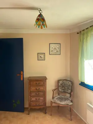 a room with a chair and a dresser and a window at Montagne d'Alaric in Moux