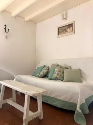 a white couch with pillows and a table in a room at Les Volets Verts in Miraval-Cabardès