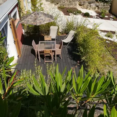 a patio with a table and chairs and an umbrella at grand studio des rivages cathares in Carcassonne