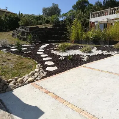 a garden with rocks and a walkway at grand studio des rivages cathares in Carcassonne