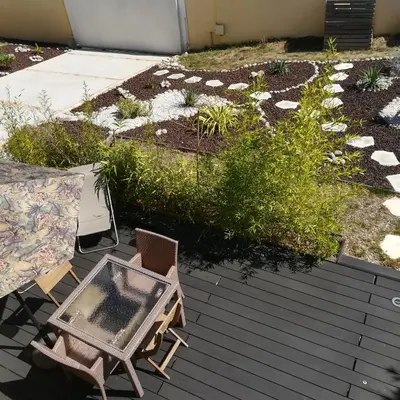 a patio with a table and chairs on a deck at grand studio des rivages cathares in Carcassonne