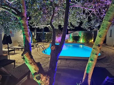 a swimming pool in a yard with trees and lights at La Casa del Arti - Hôtellerie & Spa - Centre bien-être et Piscine chauffée in Sigean