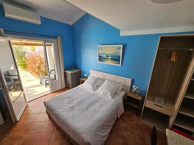 a bedroom with blue walls and a bed with white sheets at La Casa del Arti - Hôtellerie & Spa - Centre bien-être et Piscine chauffée in Sigean