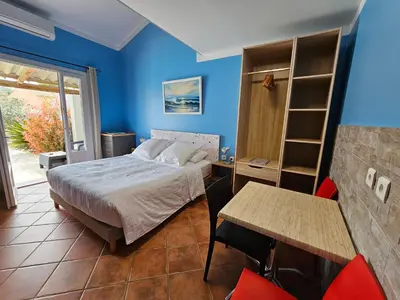 a bedroom with a bed and a desk and a table at La Casa del Arti - Hôtellerie & Spa - Centre bien-être et Piscine chauffée in Sigean