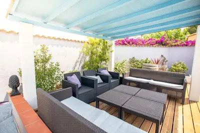a patio with chairs and tables on a deck at La Casa del Arti - Hôtellerie & Spa - Centre bien-être et Piscine chauffée in Sigean