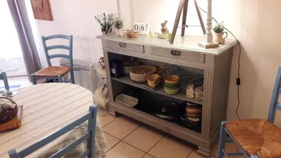 a room with a table and a cabinet with dishes at La Grange in Durban-Corbières