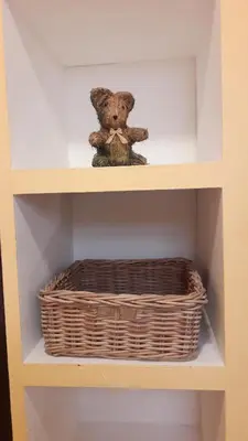 a teddy bear sitting on a shelf with a basket at La Grange in Durban-Corbières