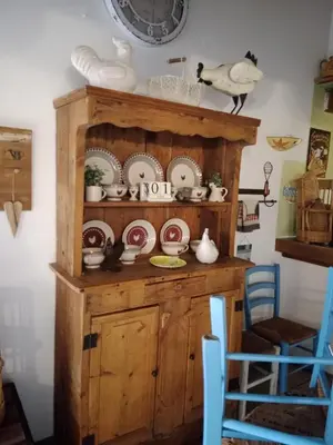 a wooden hutch with plates and dishes on it at La Grange in Durban-Corbières