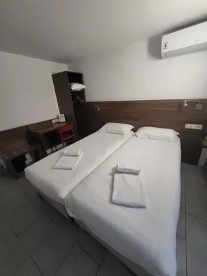 a bedroom with a white bed with two towels on it at Brit Hotel Plaisance A9/A61 in Narbonne