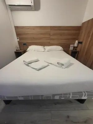 a large white bed with two white towels on it at Brit Hotel Plaisance A9/A61 in Narbonne