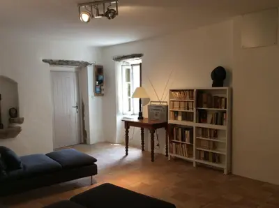 a living room with a desk and a book shelf at Maison Ancienne Minervois in La Caunette