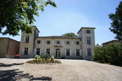 an old house with a flower bed in front of it at La Lauze in Vielmur-sur-Agout