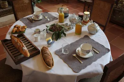 a table with a white table cloth and food on it at La Lauze in Vielmur-sur-Agout