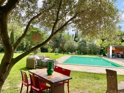a table and chairs next to a swimming pool at Le Jardin de LaCoste in Narbonne