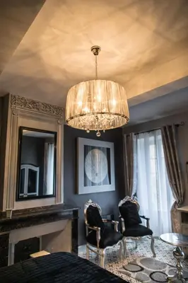 a living room with a chandelier and a fireplace at O'palmier Caché in Saint-Marcel