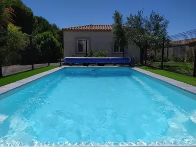a large blue swimming pool in front of a house at Le Logis de Liliana in Villemoustaussou