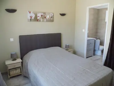 a bedroom with a bed and a bathroom at Le Logis de Liliana in Villemoustaussou