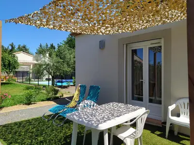 a table and chairs on a patio with lights at Le Logis de Liliana in Villemoustaussou