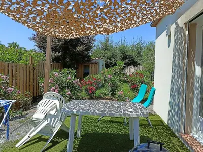 a patio with a table and chairs under an umbrella at Le Logis de Liliana in Villemoustaussou