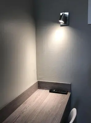 a room with a toilet and a light on the wall at Le 81 HOTEL in Castres
