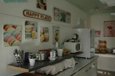 a kitchen counter with a happy price sign and a microwave at Le 81 HOTEL in Castres