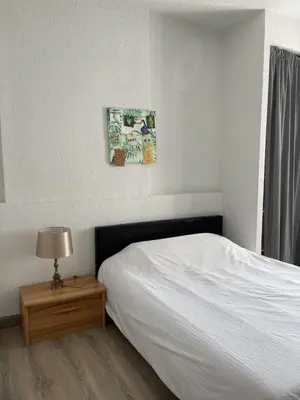 a bedroom with a bed and a table with a lamp at Les cèdres in Chalabre