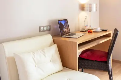 a desk with a laptop computer on top of it at Hotel La Chaumière in Quillan