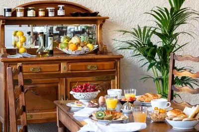 a table with breakfast foods and drinks on it at Hotel La Chaumière in Quillan