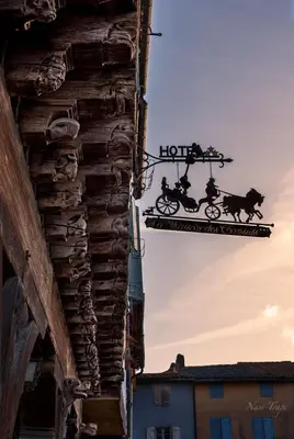 a sign hanging from the side of a building at La Maison des Consuls in Mirepoix