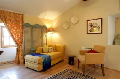 a living room with a couch and a chair at Maison de Textile in Montolieu