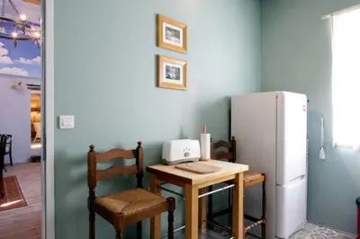 a kitchen with a small table and a refrigerator at Maison de Textile in Montolieu