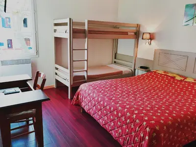a bedroom with a bed and a bunk bed at Logis Hotels - Hôtel et Restaurant de la Montagne Noire in Dourgne