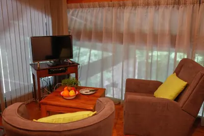 a living room with a tv and a chair and a table at Moulin d'entre les roches in Puivert