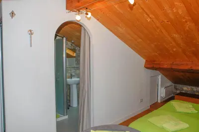 a room with a wooden ceiling and a mirror at Moulin d'entre les roches in Puivert