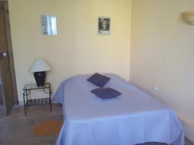 a bedroom with a bed with blue sheets and a lamp at La Vadrouille in Sigean