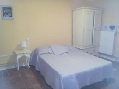 a bedroom with a white bed and a dresser at La Vadrouille in Sigean