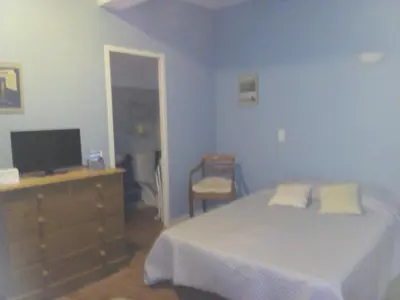 a bedroom with a bed and a dresser with a television at La Vadrouille in Sigean