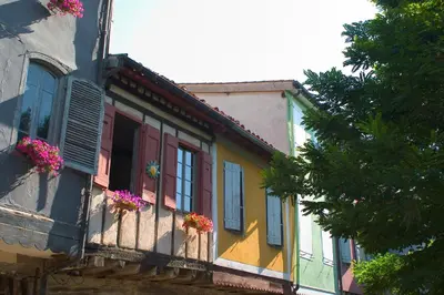 a colorful building with flower boxes on a balcony at Hôtel Le Commerce in Mirepoix