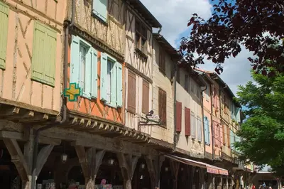 an old building with colorful windows on a street at Hôtel Le Commerce in Mirepoix