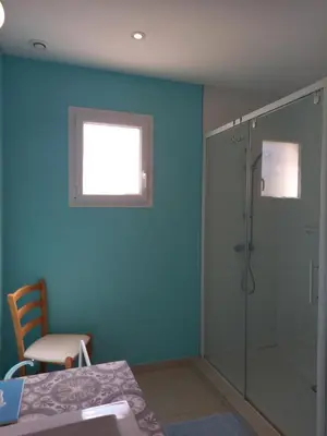 a bathroom with a shower and a blue wall at Gîte Vigneron du Domaine d'Alon in Magrie
