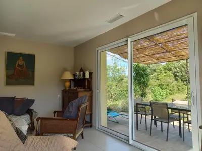 a living room with a sliding glass door to a patio at Gîte Vigneron du Domaine d'Alon in Magrie
